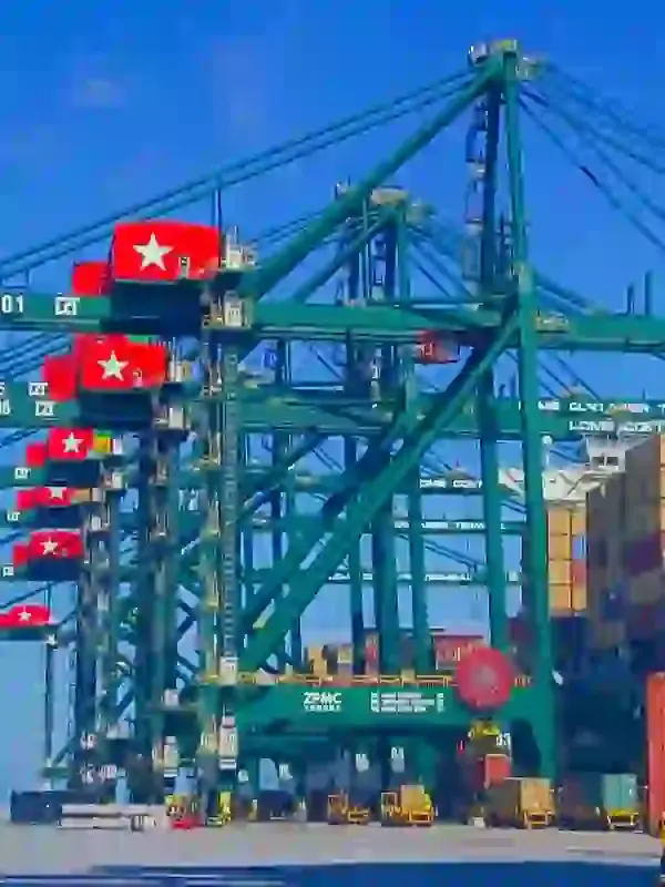 Alignement de grandes grues portuaires vertes déchargeant des conteneurs sur un terminal maritime par temps clair au port autonome de lomé